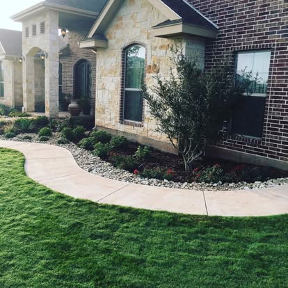 Finished front landscape with lawn, walkway, and planted beds